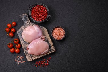 Koyu beton bir masada baharat ve otlarla taze tavuk filetosu. Et yemekleri için hazırlık.