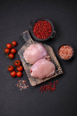 Koyu beton bir masada baharat ve otlarla taze tavuk filetosu. Et yemekleri için hazırlık.