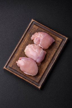 Koyu beton bir masada baharat ve otlarla taze tavuk filetosu. Et yemekleri için hazırlık.