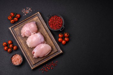 Koyu beton bir masada baharat ve otlarla taze tavuk filetosu. Et yemekleri için hazırlık.