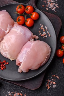 Koyu beton bir masada baharat ve otlarla taze tavuk filetosu. Et yemekleri için hazırlık.