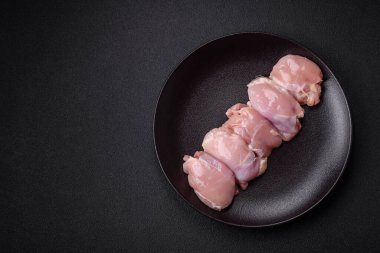 Koyu beton bir masada baharat ve otlarla taze tavuk filetosu. Et yemekleri için hazırlık.