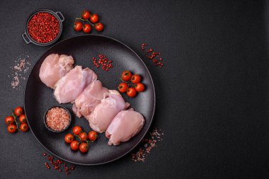 Koyu beton bir masada baharat ve otlarla taze tavuk filetosu. Et yemekleri için hazırlık.