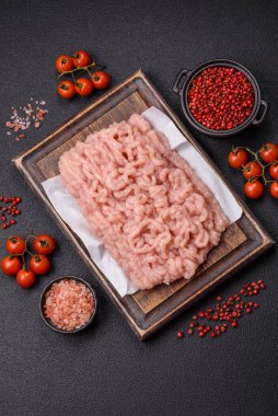 Koyu beton arka planda tuz ve baharatlı taze çiğ tavuk kıyması.