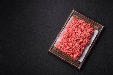 Koyu beton arka planda tuzlu ve baharatlı taze çiğ et.