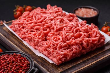 Koyu beton arka planda tuzlu ve baharatlı taze çiğ et.