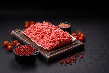 Koyu beton arka planda tuzlu ve baharatlı taze çiğ et.