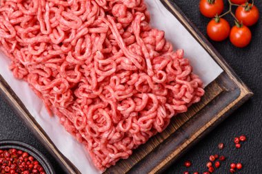 Koyu beton arka planda tuzlu ve baharatlı taze çiğ et.