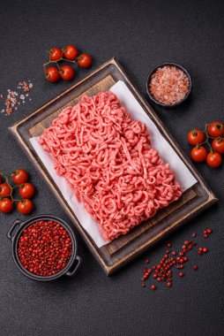 Koyu beton arka planda tuzlu ve baharatlı taze çiğ et.