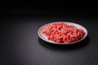 Koyu beton arka planda tuzlu ve baharatlı taze çiğ et.