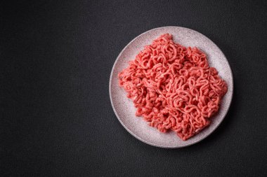 Koyu beton arka planda tuzlu ve baharatlı taze çiğ et.