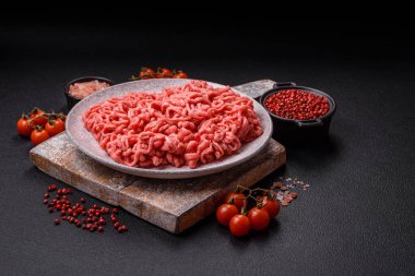 Koyu beton arka planda tuzlu ve baharatlı taze çiğ et.