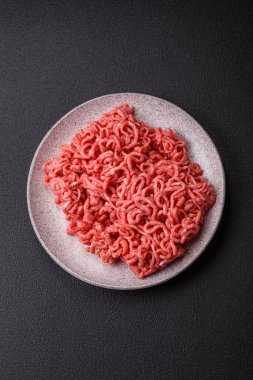 Koyu beton arka planda tuzlu ve baharatlı taze çiğ et.