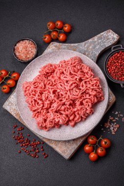 Koyu beton arka planda tuzlu ve baharatlı taze çiğ et.