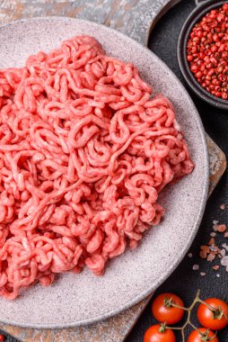 Koyu beton arka planda tuzlu ve baharatlı taze çiğ et.