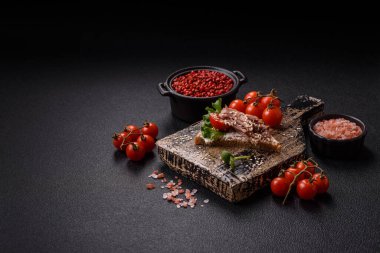 Koyu beton bir zemin üzerinde jambon, mantar ve dana eti, domates ve mikroçerez içeren çeşitli tostlar veya bruschetta çeşitleri