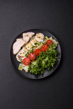 Tavuk göğsü, yumurta, domates ve salatayla dolu bir kasede taze sezar salatası.