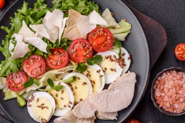 Tavuk göğsü, yumurta, domates ve salatayla dolu bir kasede taze sezar salatası.