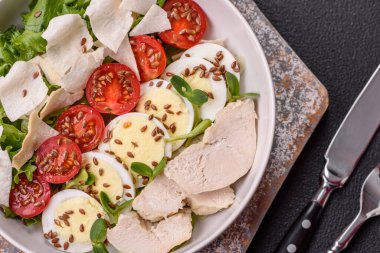 Tavuk göğsü, yumurta, domates ve salatayla dolu bir kasede taze sezar salatası.