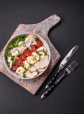 Tavuk göğsü, yumurta, domates ve salatayla dolu bir kasede taze sezar salatası.