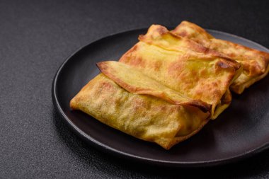 Koyu beton arka planda seramik tabakta ev yapımı krep.