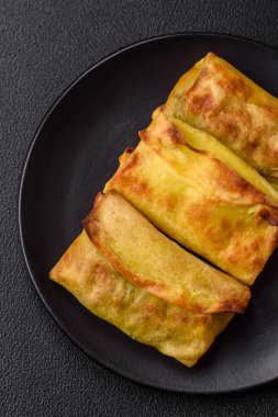 Koyu beton arka planda seramik tabakta ev yapımı krep.