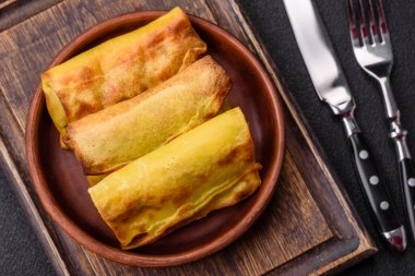 Koyu beton arka planda seramik tabakta ev yapımı krep.