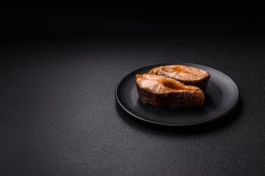 Lezzetli kırmızı somon balığı, çimento arka planda baharat ve otlarla kızartılmış.