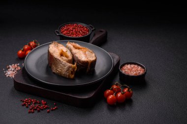 Lezzetli kırmızı somon balığı, çimento arka planda baharat ve otlarla kızartılmış.