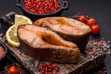 Lezzetli kırmızı somon balığı, çimento arka planda baharat ve otlarla kızartılmış.