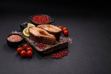 Lezzetli kırmızı somon balığı, çimento arka planda baharat ve otlarla kızartılmış.