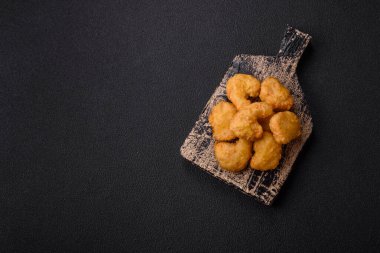 Delicious fresh crispy chicken nuggets on a dark concrete background. Unhealthy food, fast food