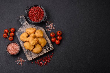 Delicious fresh crispy chicken nuggets on a dark concrete background. Unhealthy food, fast food