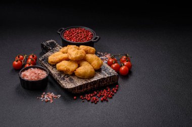 Delicious fresh crispy chicken nuggets on a dark concrete background. Unhealthy food, fast food