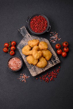 Delicious fresh crispy chicken nuggets on a dark concrete background. Unhealthy food, fast food