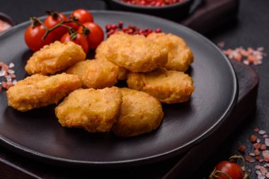 Delicious fresh crispy chicken nuggets on a dark concrete background. Unhealthy food, fast food