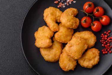 Delicious fresh crispy chicken nuggets on a dark concrete background. Unhealthy food, fast food