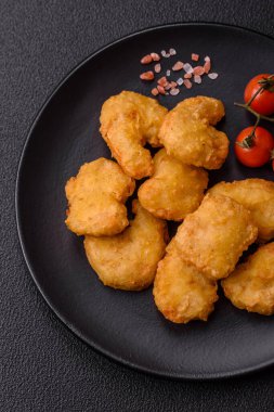 Delicious fresh crispy chicken nuggets on a dark concrete background. Unhealthy food, fast food