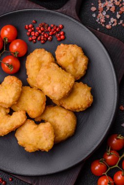 Delicious fresh crispy chicken nuggets on a dark concrete background. Unhealthy food, fast food