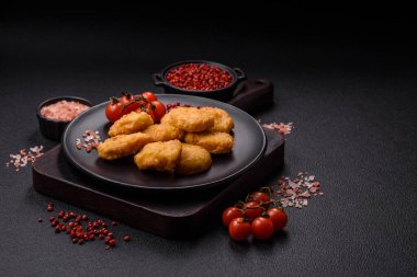 Delicious fresh crispy chicken nuggets on a dark concrete background. Unhealthy food, fast food