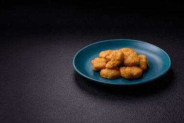 Delicious fresh crispy chicken nuggets on a dark concrete background. Unhealthy food, fast food