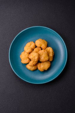 Delicious fresh crispy chicken nuggets on a dark concrete background. Unhealthy food, fast food