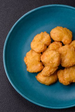 Delicious fresh crispy chicken nuggets on a dark concrete background. Unhealthy food, fast food