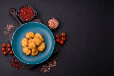 Delicious fresh crispy chicken nuggets on a dark concrete background. Unhealthy food, fast food