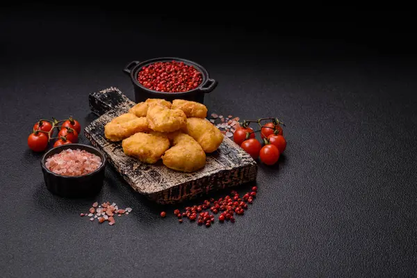 Koyu beton arka planda lezzetli çıtır tavuk nuggetları. Sağlıksız yemek, fast food