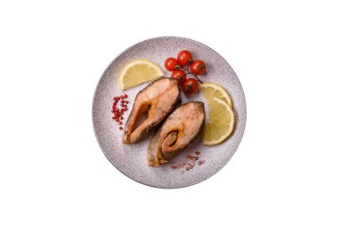 Lezzetli kırmızı somon balığı, çimento arka planda baharat ve otlarla kızartılmış.