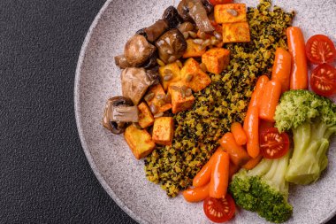 Renkli vejetaryen yemeği tofu, brokoli, kinoa, mantar ve havuçtan oluşur.