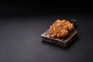 Lezzetli kızarmış domuz ya da koyu beton arka planda tuz ve baharatla ekilmiş tavuk pirzolası.