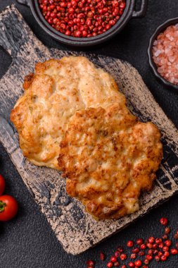Lezzetli kızarmış domuz ya da koyu beton arka planda tuz ve baharatla ekilmiş tavuk pirzolası.