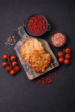 Lezzetli kızarmış domuz ya da koyu beton arka planda tuz ve baharatla ekilmiş tavuk pirzolası.